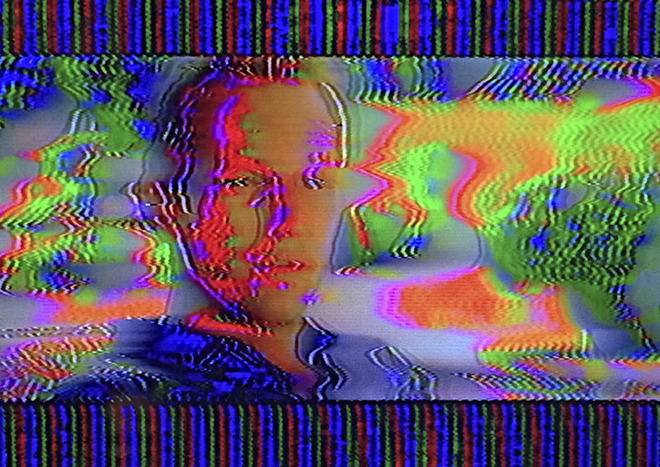 Portrait, analog glitch image from a performance, captured from a video monitor